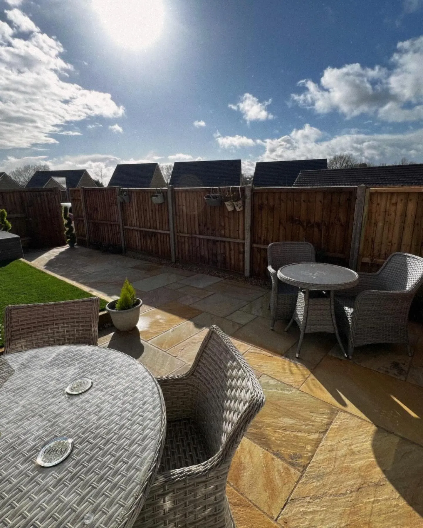 A patio with a table and chairs and a fence.
